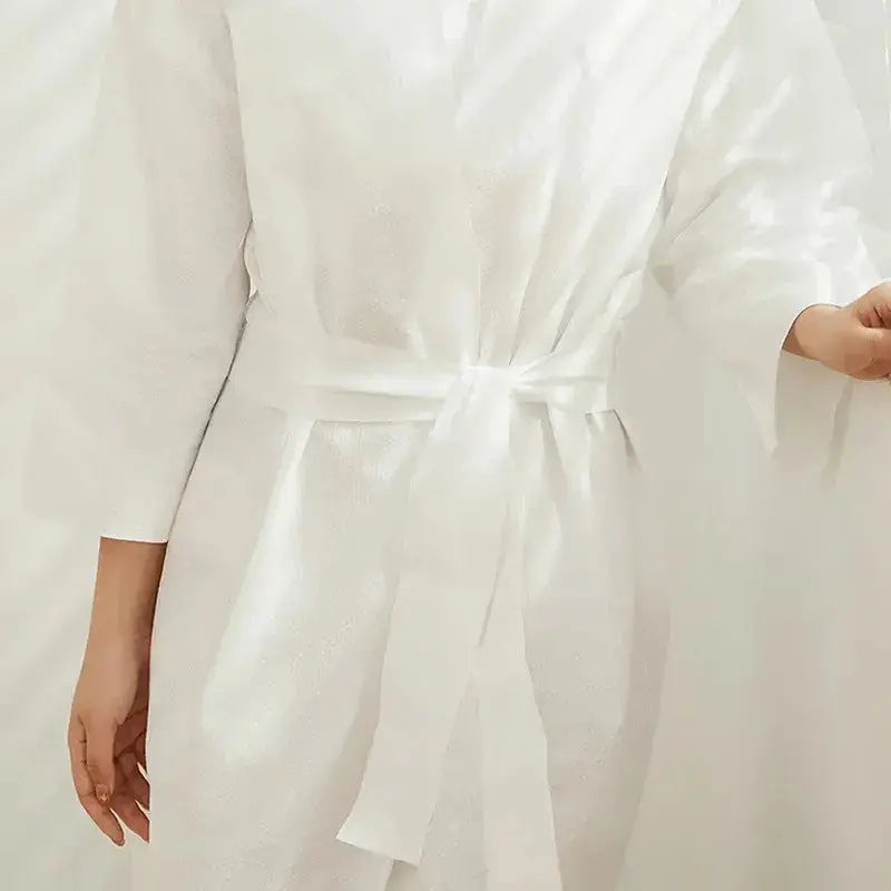 Premium disposable nonwoven robes for luxury hotels and spas, opaque and breathable, manufactured by Little Cotton B2B facility.